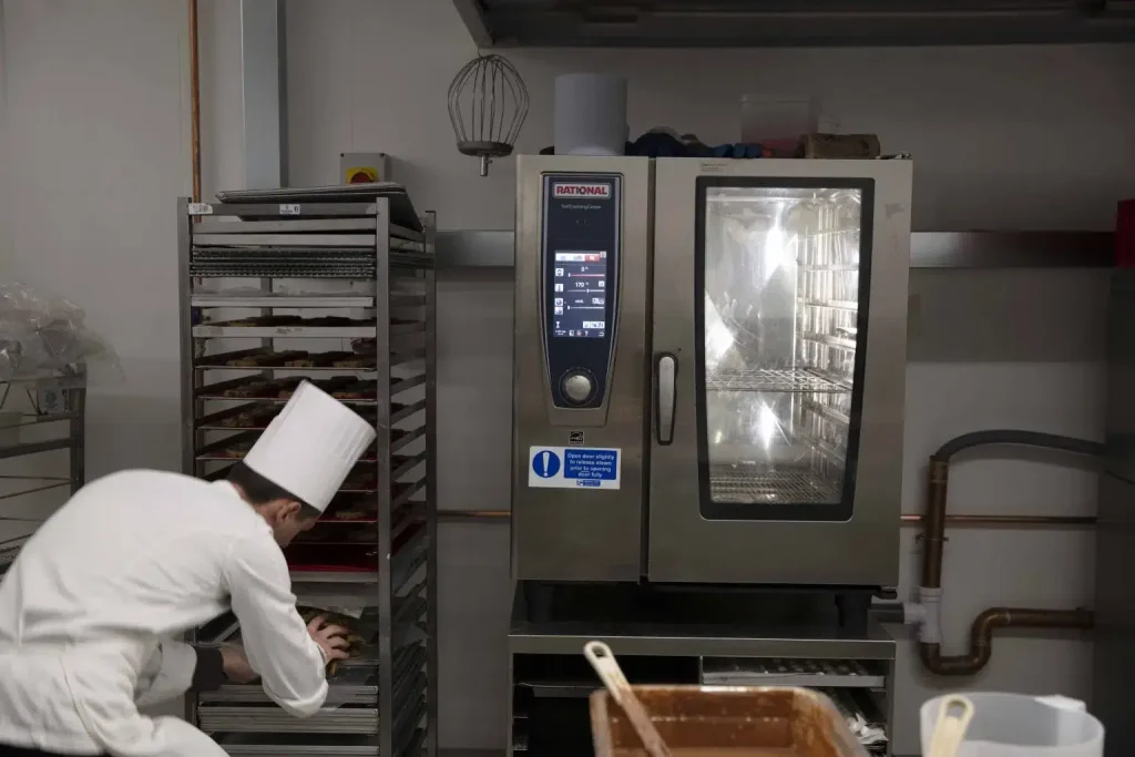 chef placing food on a stack of trays