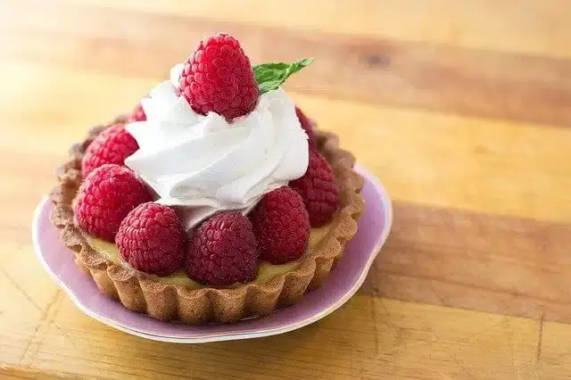 mini pastry topped with raspberries and cream