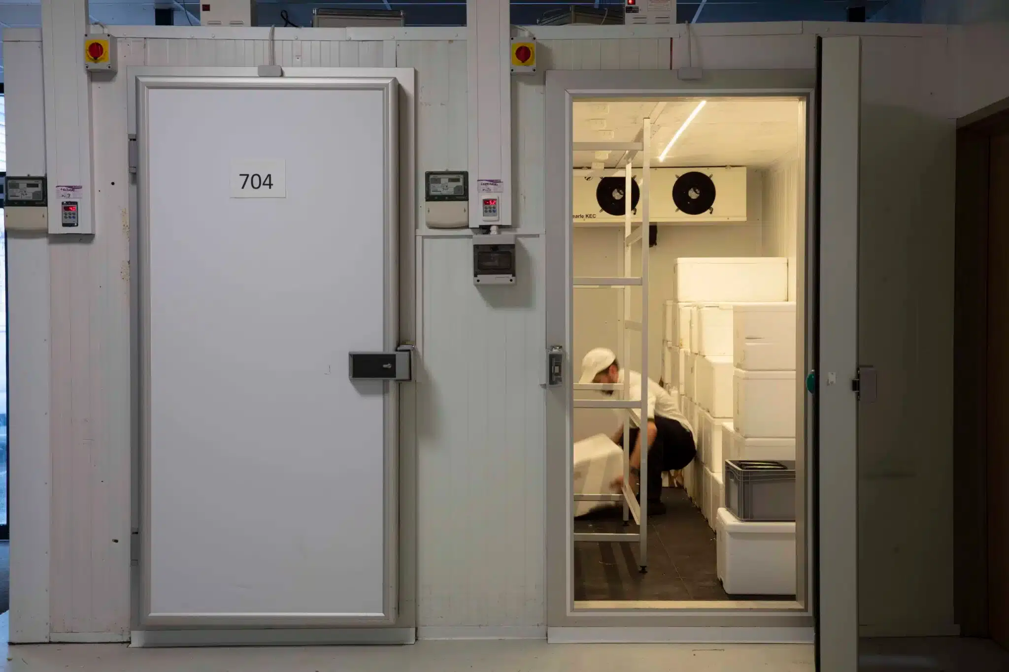 man placing a large box into a cold storage room